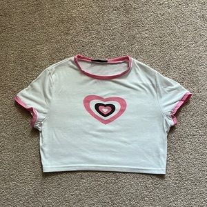 White crop top with pink heart and sleeve and collar details.